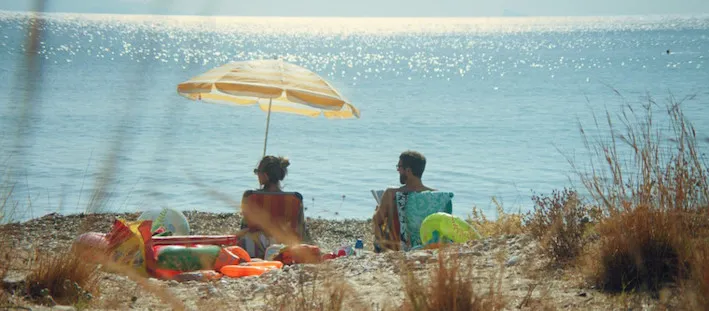 Two people sitting on the beach.