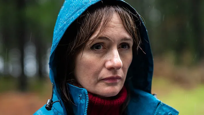 A woman wearing a blue raincoat. 