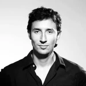 A black and white photo of a light skinned man with curly hair