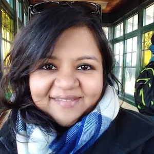 A woman smiling with a scarf around her neck