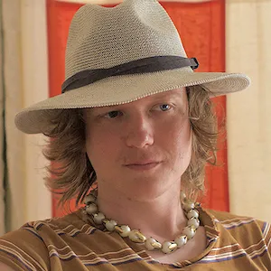 Light skinned person with light hair in a hat. 