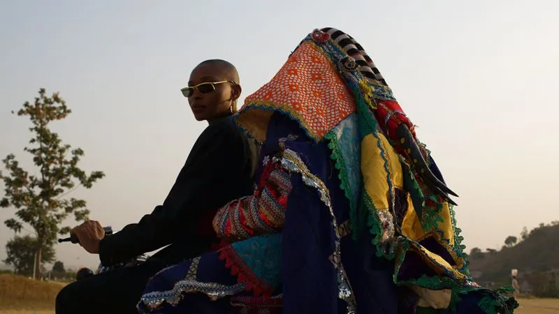 woman sitting on pile of quilted fabric outdoors