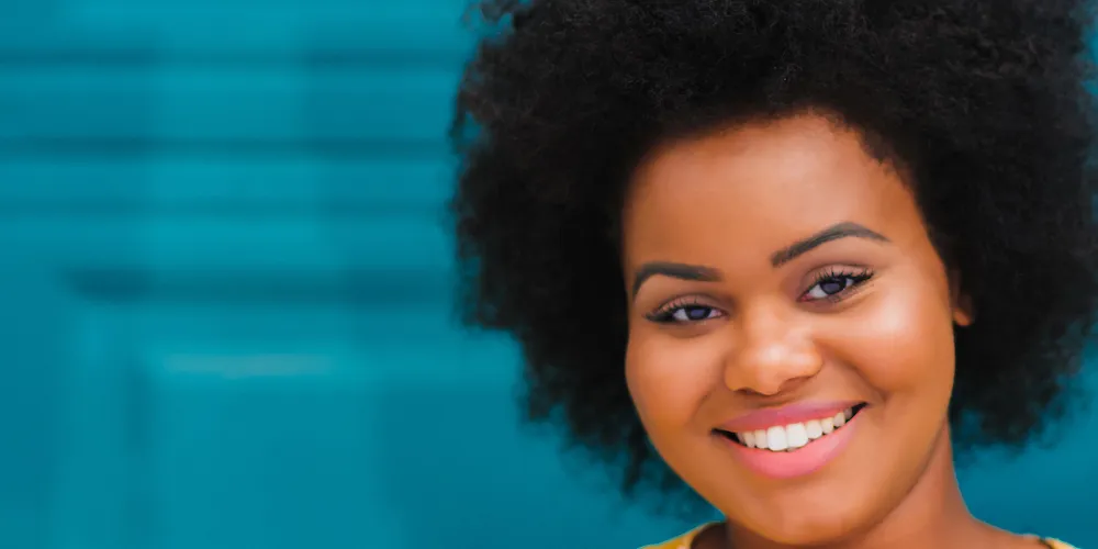 Woman with color smiling with bright blue background