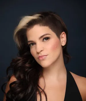 Light-skinned with half-shaved head, long brown hair on the other side, blond shock of color on the left side of her hair.