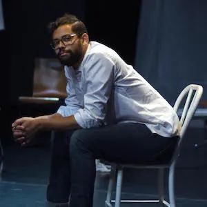 Man sitting on a chair, looking at the camera