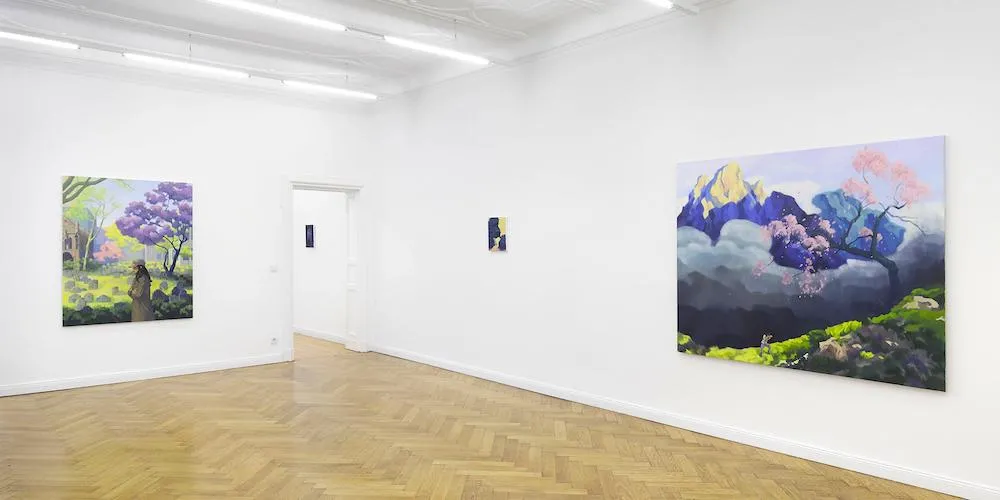 Two pieces of mounted artwork, each framed by a different doorway in a gallery. 