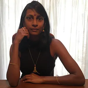 South Asian woman sitting with her hand on face