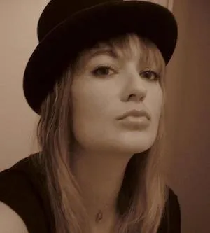 A white woman with blond hair in a hat.