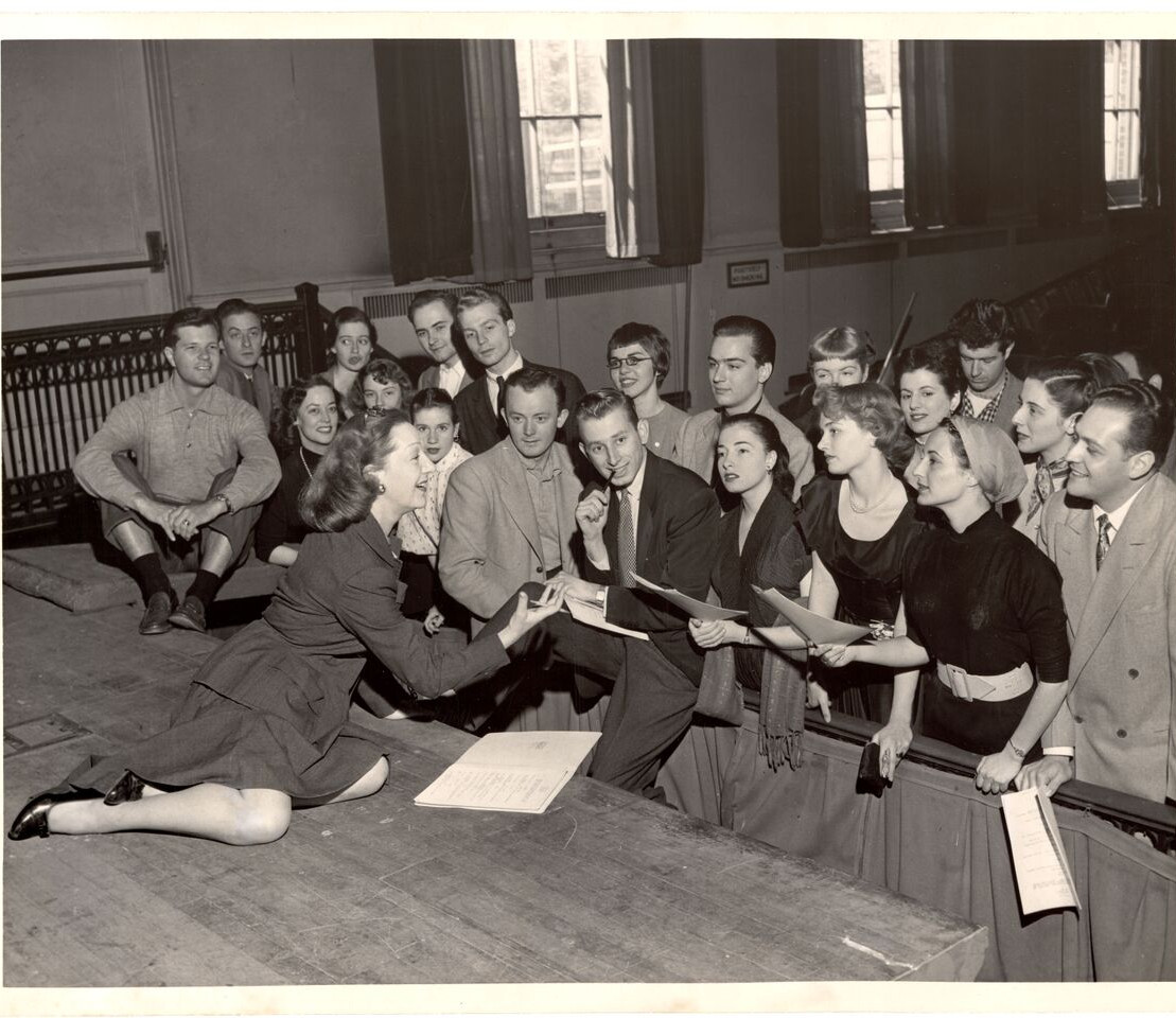 woman on stage performing for students