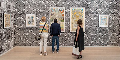 people viewing art gallery with black and white wallpaper