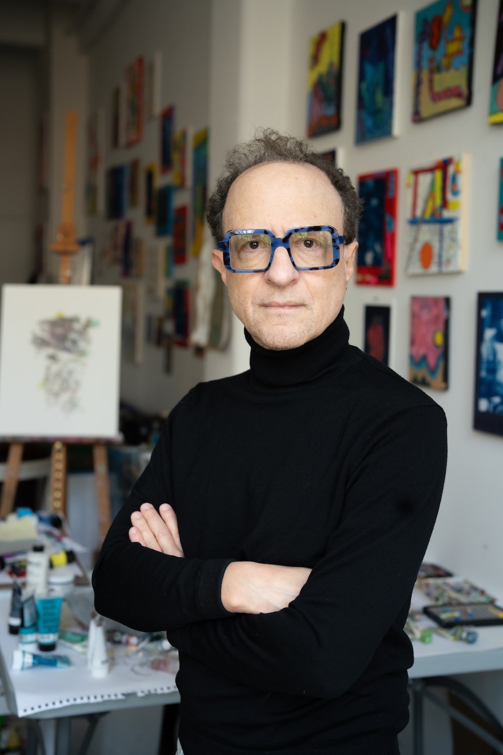 white man wearing a black turtle neck sweater and glasses