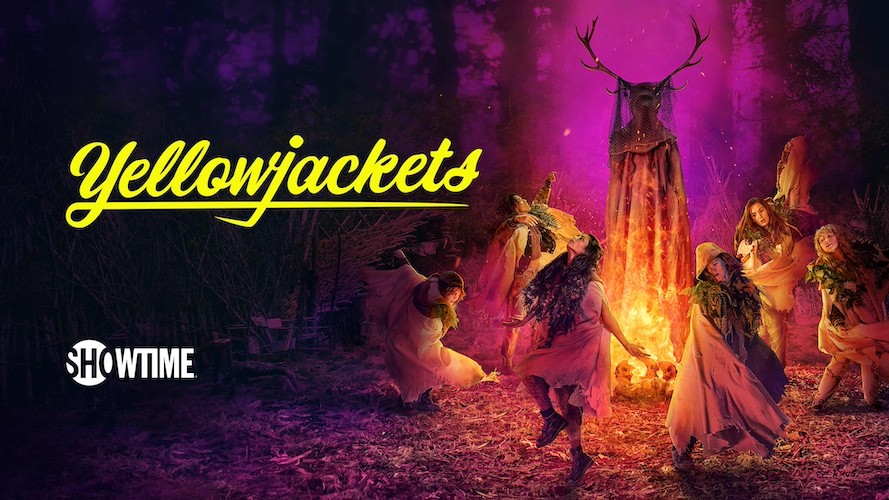 a group of girls dance around a bonfire near a cloaked figure