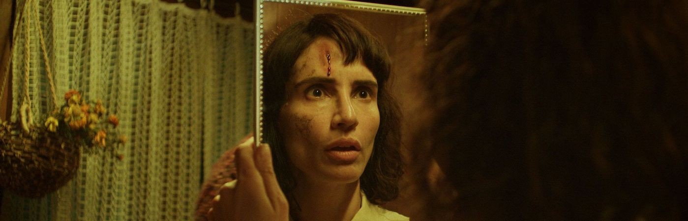 Still from The Cow Who Sang a Song Into the Future, a woman looks at herself in a mirror. 