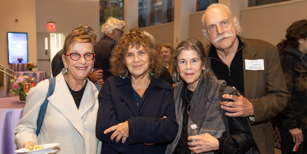 Dean Carol stands with two women and a man at a reception 