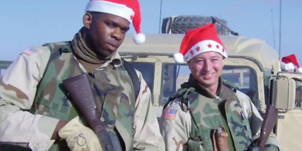 Two soldiers wearing santa hats