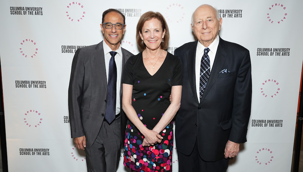 3 people pose in front of a step & repeat