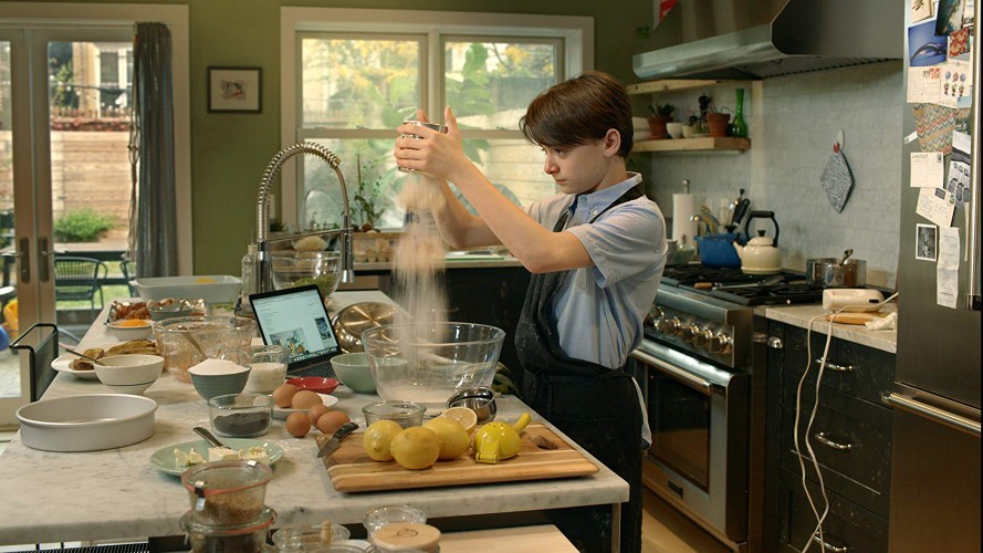 A young man bakes in a kitchen.