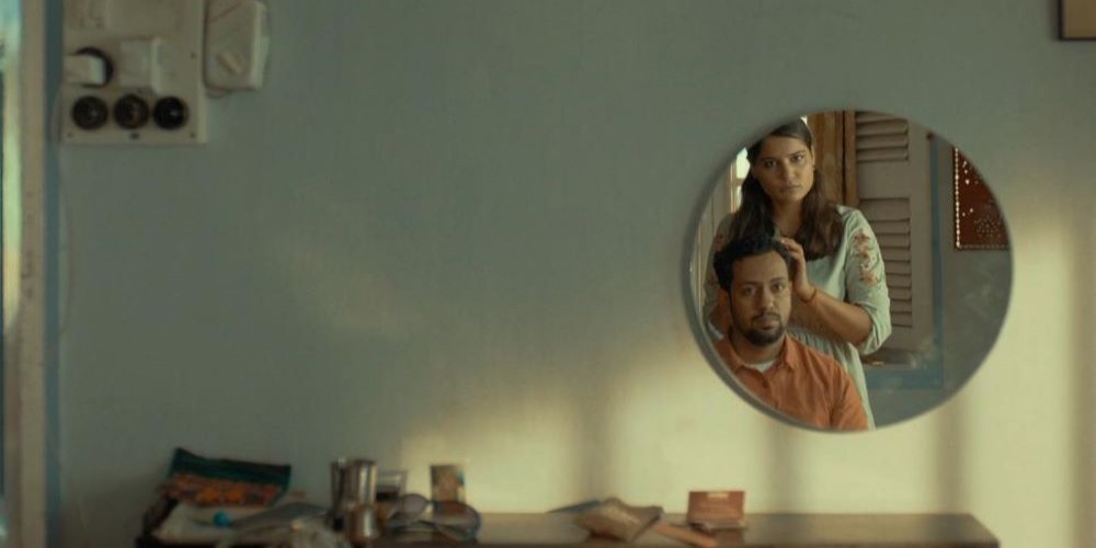 Two people as viewed in the reflection of a mirror