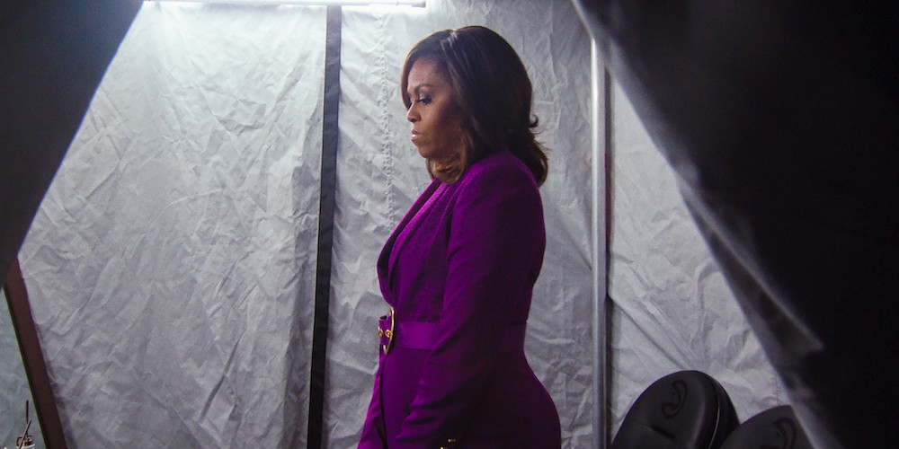 Michelle Obama backstage in a purple coat