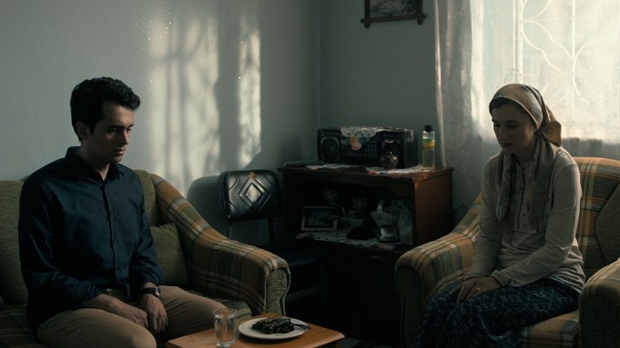 Still from 'Between Two Dawns' two people sitting in a dark room