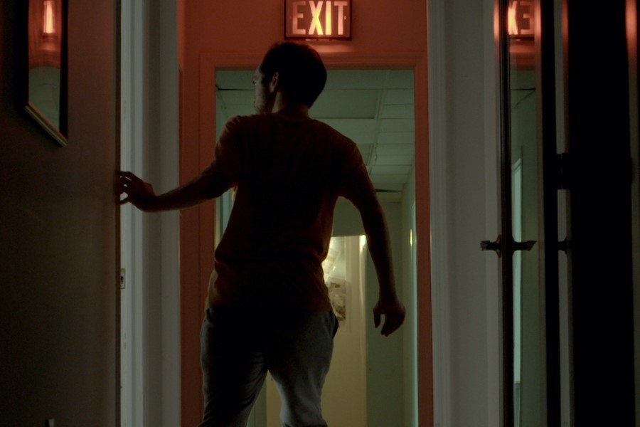 figure in dark hallway walking towards exit