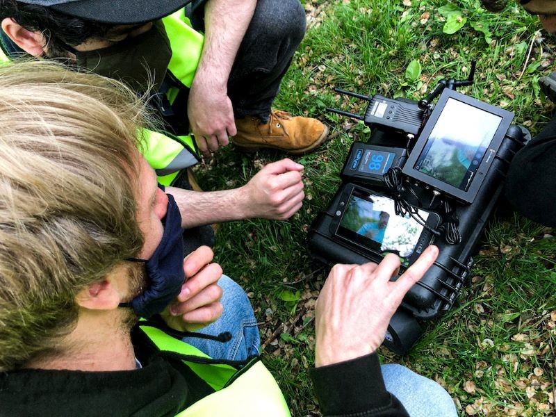 two men looking at a video camera