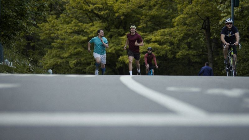 still from 'The Fastest Man' two men running vigorously through a park