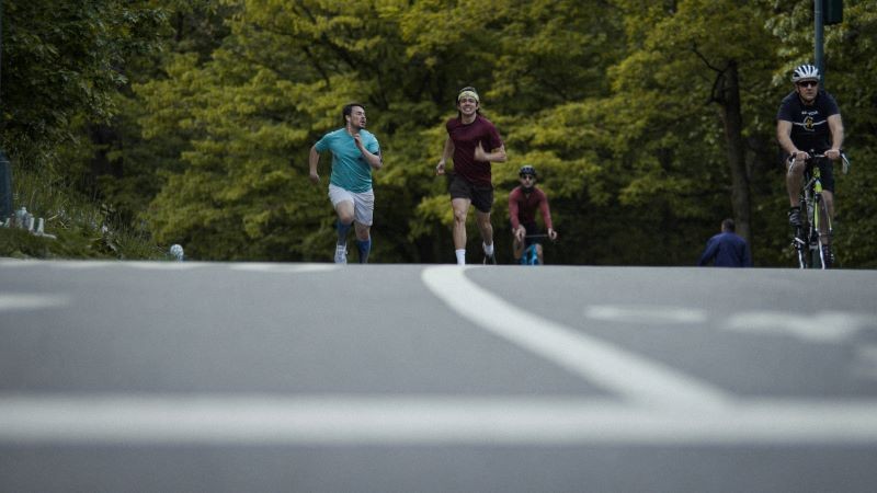 two men running vigorously through a park