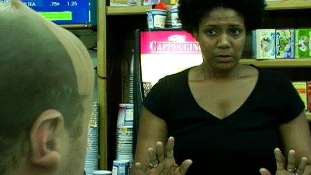 Still from 'Hold Up' woman with hands held up in front of her
