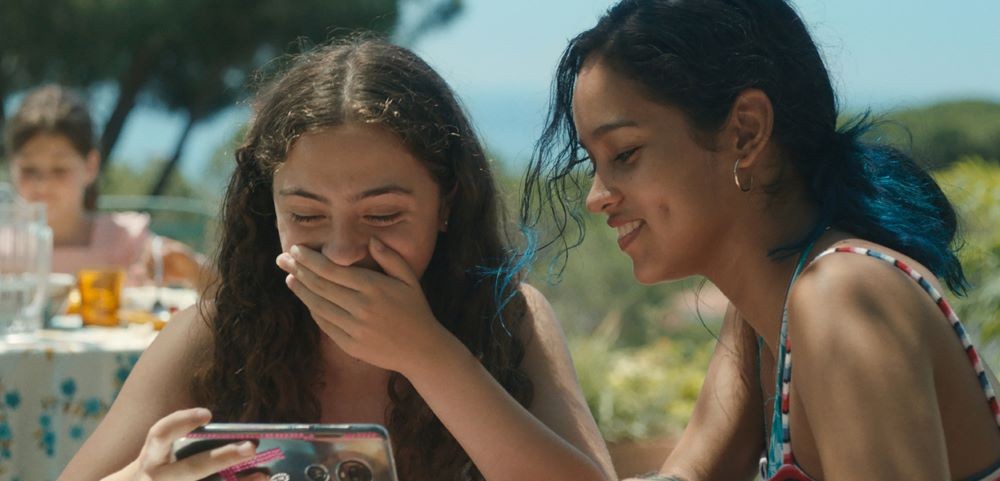 two girls looking at a phone and laughing