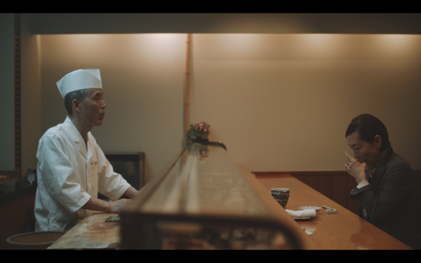 Still from Kio Shijiki's 8-12 film Person seated across a bar from a chef