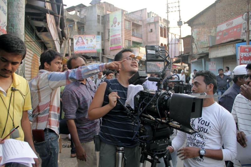 Still from 'Ek Hazarachi Note (1000 Rupee Note)' many people in street with film camera