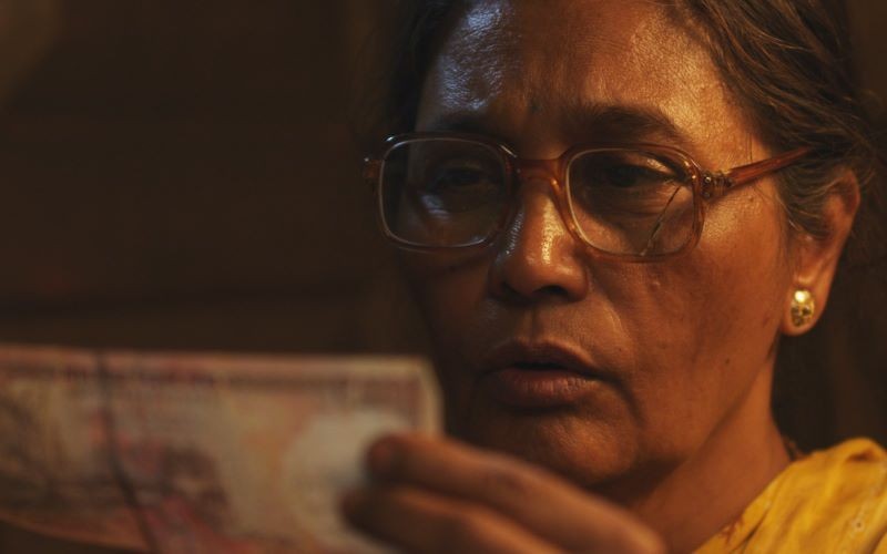 Still from 'Ek Hazarachi Note (1000 Rupee Note)' woman staring at money note