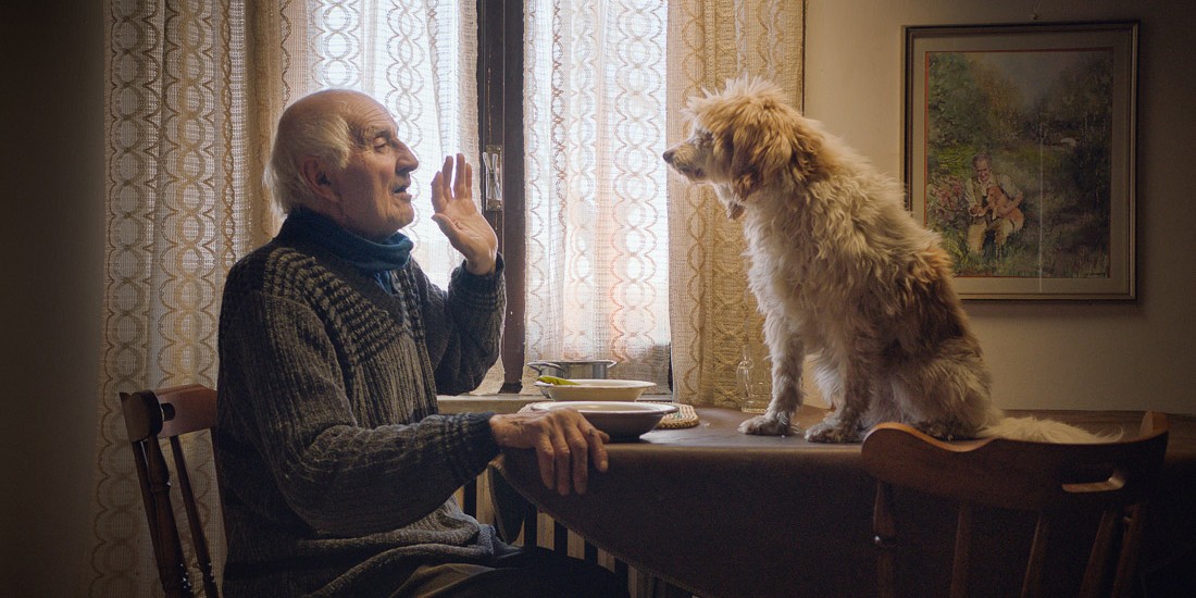 Still from 'The Truffle Hunters'. A man looks towards a dog.
