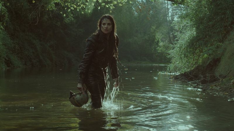 Still from 'The Cow Who Sang A Song Into The Future' woman in river in forest