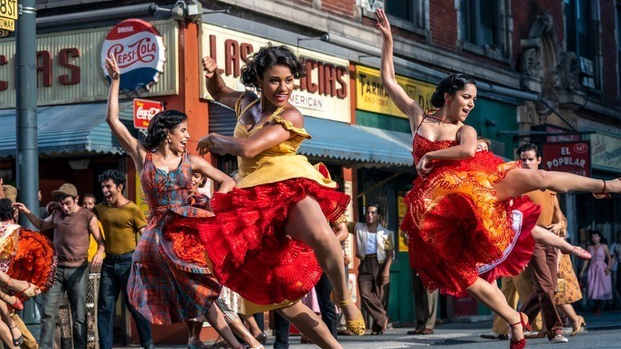 women dancing in red dresses in city street