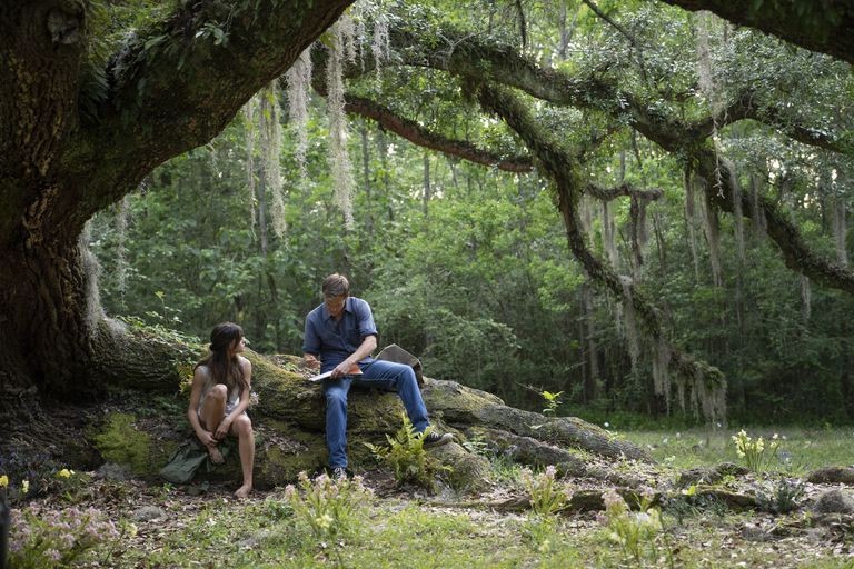 Two people under a large tree draped with Spanish Moss