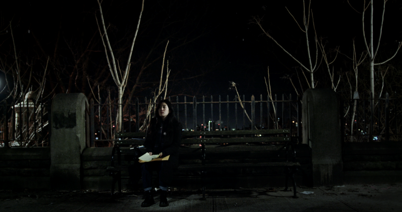 Woman on park bench at night
