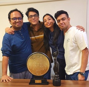 Four people with awards. 