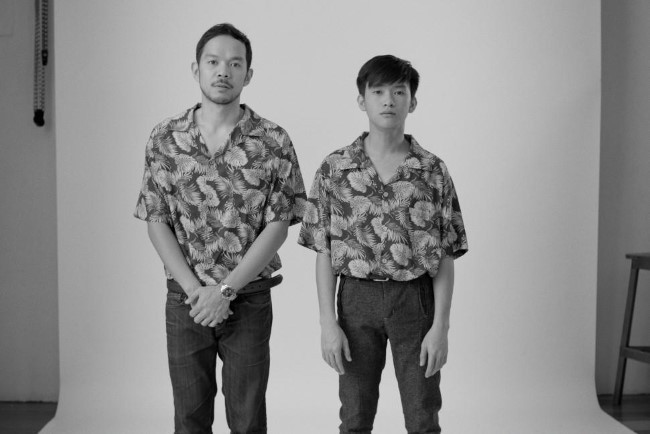 Two boys wearing Hawaiian shirts having their photograph taken