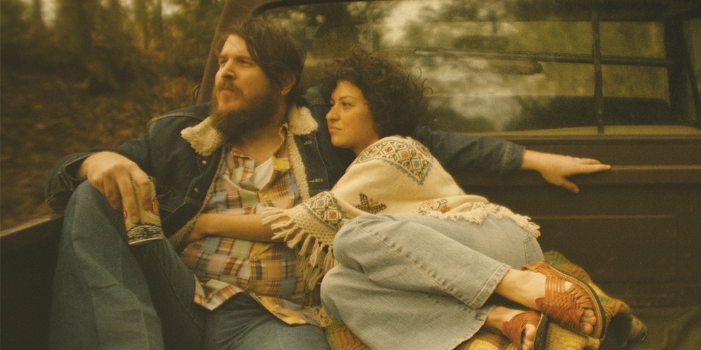 A couple holding each other in the bed of a truck