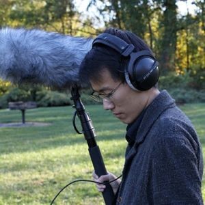 Headshot of Mengtai Zhang holding a boom mic.