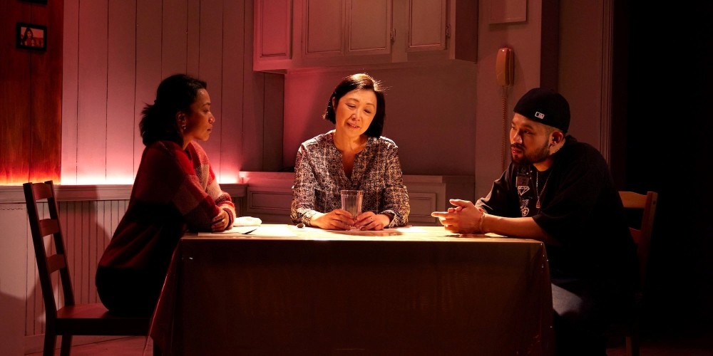 Two women and a man at a dinner table.