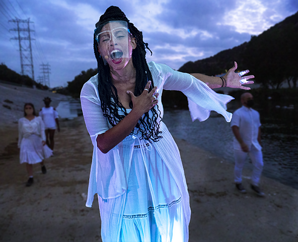 Woman in white with plastic face-shield singing