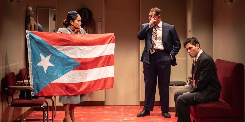 Woman holds Puerto Rican flag next to men in suits on a stage.