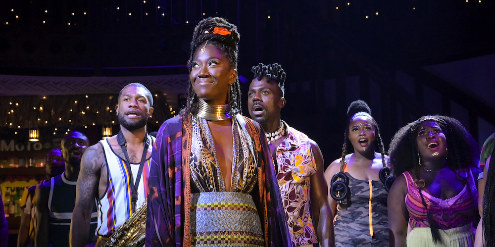 Group of people in colorful clothing on stage. 