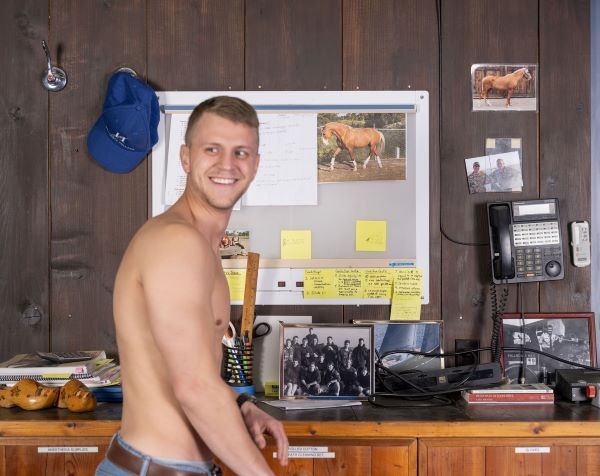Shirtless man at a cluttered countertop