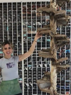 Fishman standing next to 'Some days I’m edible' (93” x 21” x 21,” reishi mycelium, firewood, rye, wood, cardboard, egg yolk, tanned salmon skin, chitosan, 2023). Fishman standing next to 'Some days I’m edible' (93” x 21” x 21,” reishi mycelium, firewood, rye, wood, cardboard, egg yolk, tanned salmon skin, chitosan, 2023).