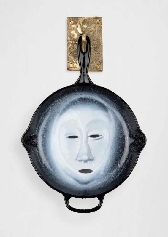 Cookware sculpture with a face