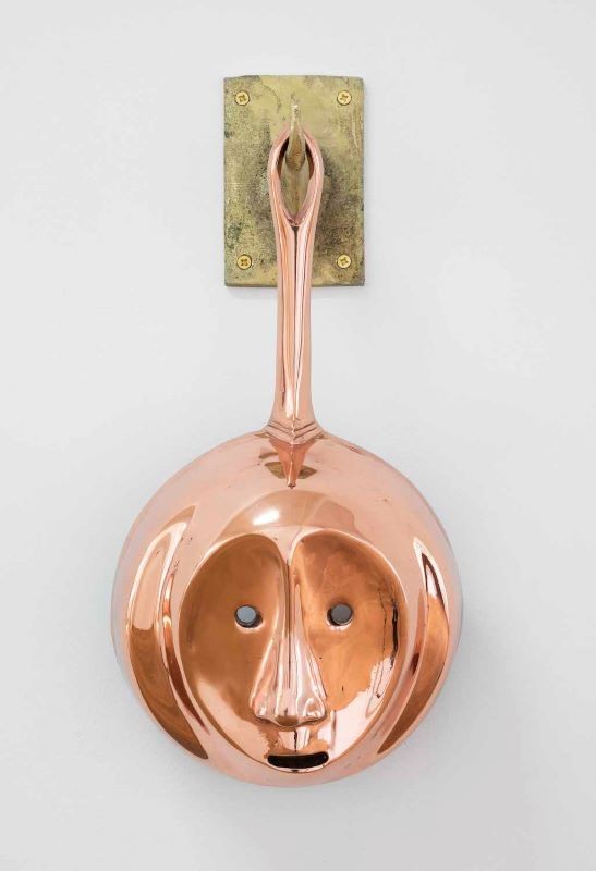 Cookware sculpture with a face